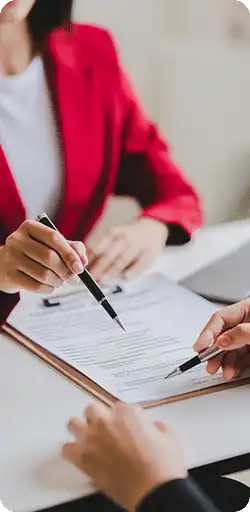 Person in red jacket holding pen over document